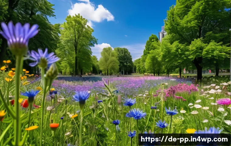 야생화 식물의 생태적 기능과 도시 적용 - A vibrant urban wildflower meadow in a German city park during late spring, featuring a diverse mix ...